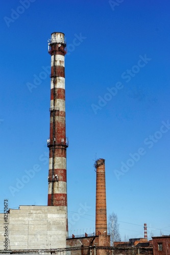 Three old factory pipes. blue sky background