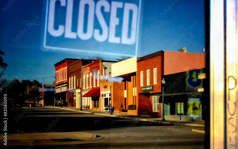closed sign in shop door window with reflection