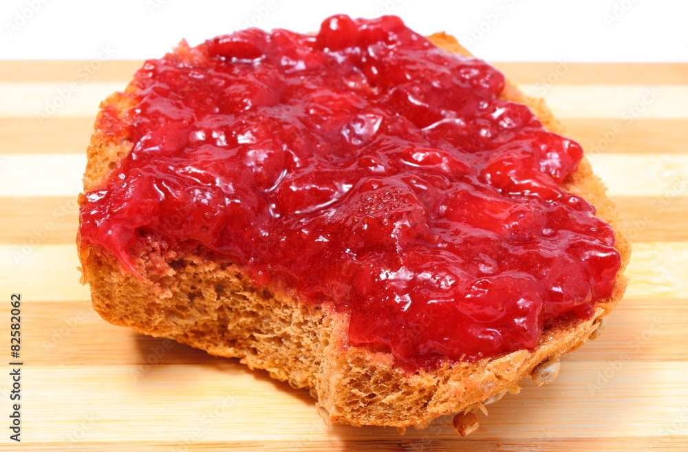 Obraz premium Portion of wheat bread with strawberry jam
