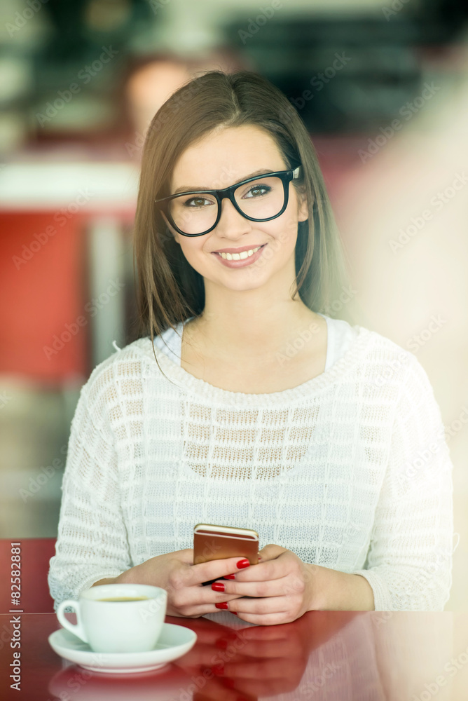Girl with a phone in cafe Girl with a phone in cafe