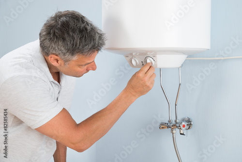 Man Adjusting Temperature Of Electric Boiler photo