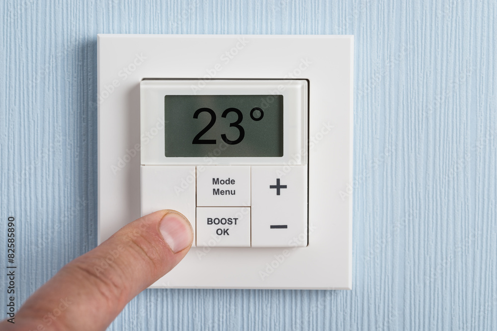 Person Adjusting Temperature Of Thermostat Person Adjusting Temperature Of Thermostat