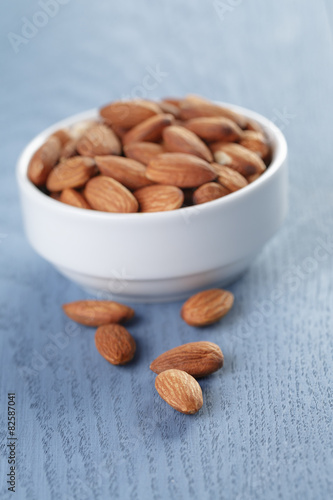 roasted almonds in white bowl on wooden table photo