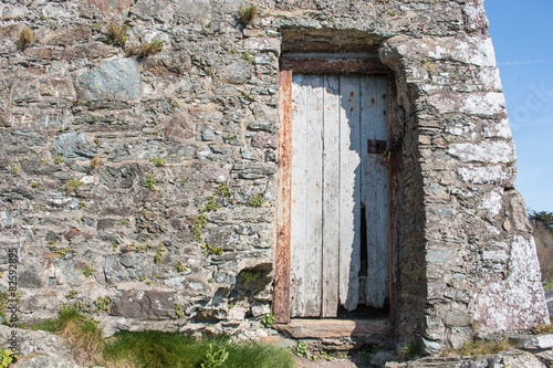 Hintergrund – irische Natursteinmauer mit Holztür
