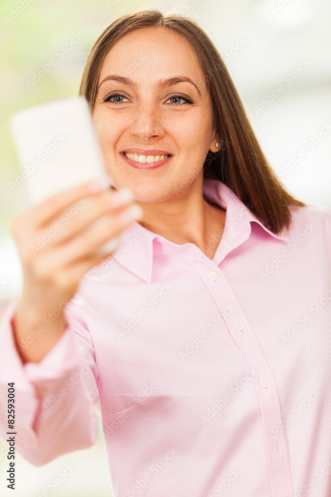 Smiling caucasian woman with pink shirt is doing a selfie with h Smiling caucasian woman with pink shirt is doing a selfie with h