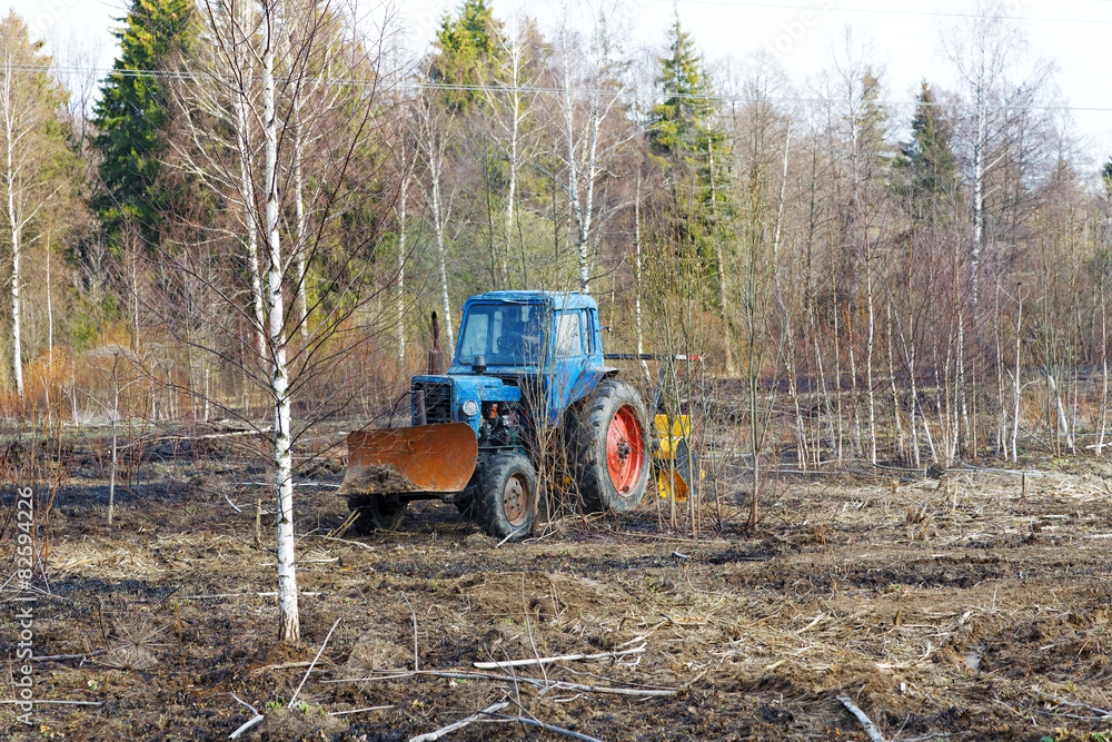 Fototapeta premium tractor work the land among the trees