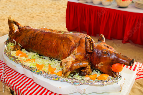 Decorated and roast suckling pig on a table on banquet. 