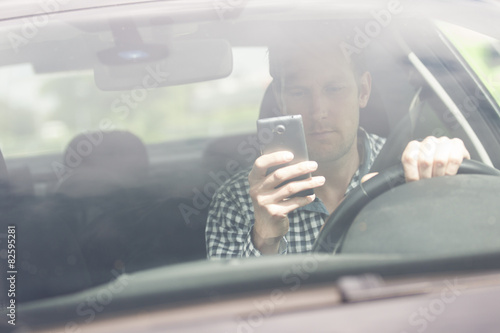 Man Using Cell Phone While Driving Car