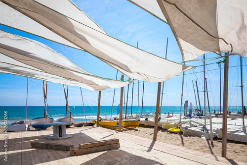 Fotografie, Obraz Awnings in sails shape covering relax area on beach