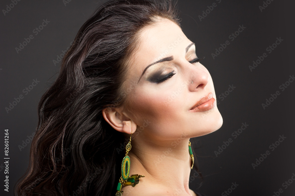 Naklejka premium Burning brunette with flying hair on a black background