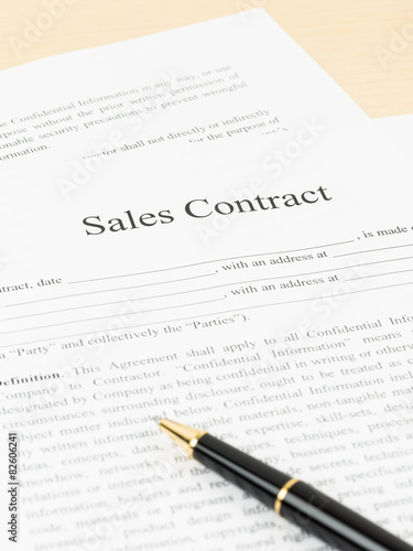 Sales contract document with pen, document is mock-up