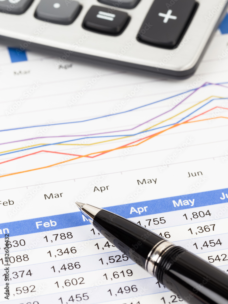 Sales report analysis with pen, and calculator Sales report analysis with pen, and calculator
