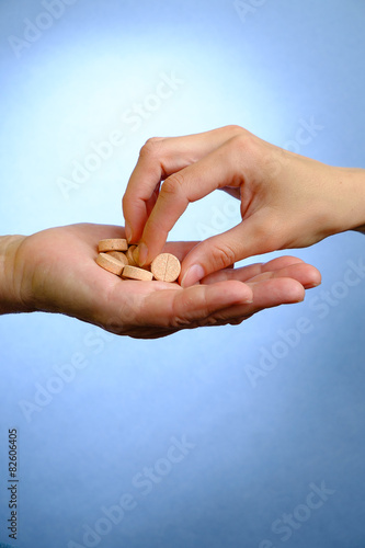 Hand of young woman and elderly woman holding the pills