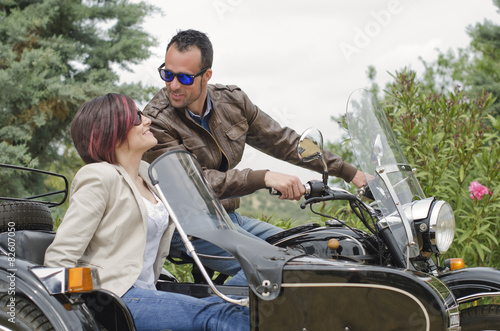 Couple posing in sidecar custom bike