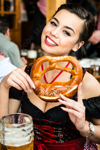 Woman in Dirndl eating Oktoberfest Pretzel photo