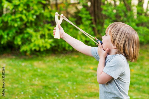 Valokuva Cute little boy playing with slingshot, outdoors