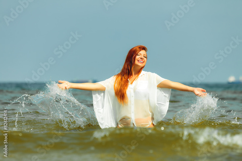 Vacation. Girl splashing water having fun on the sea.