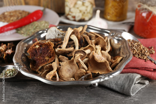 Dried mushrooms with spices on wooden background