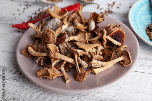 Dried mushrooms in plate on wooden background