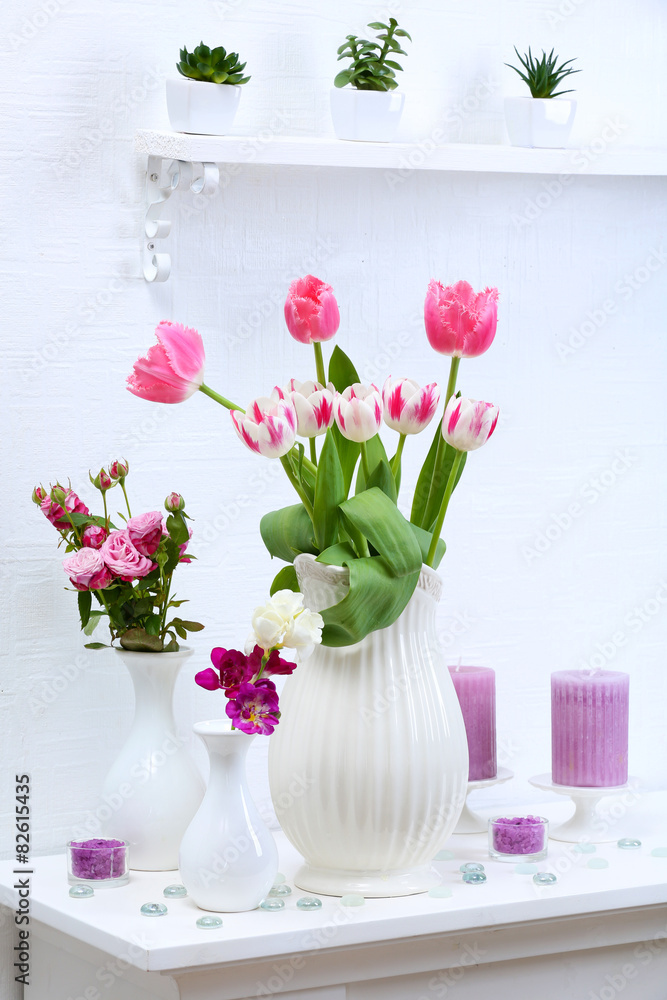 Beautiful composition with different flowers in vases on wall background Beautiful composition with different flowers in vases on wall background