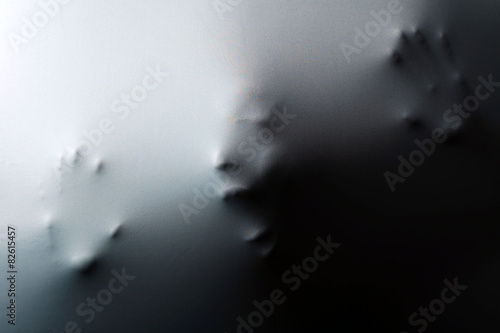 Obraz na plátně Screaming human face with hands pressing through fabric as horror background