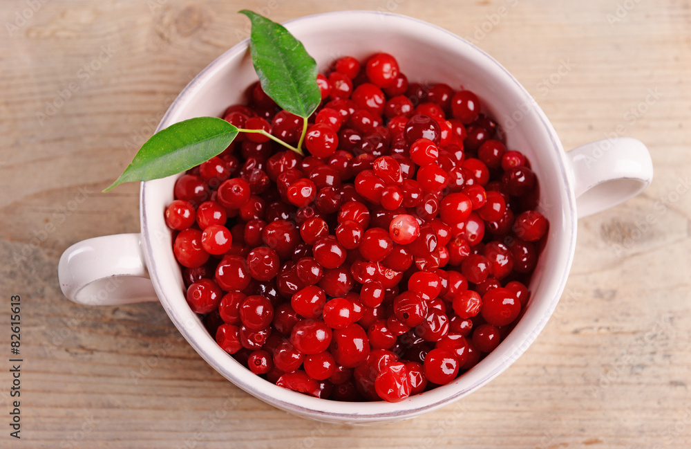 Red currant in bowl on wooden table, closeup Red currant in bowl on wooden table, closeup