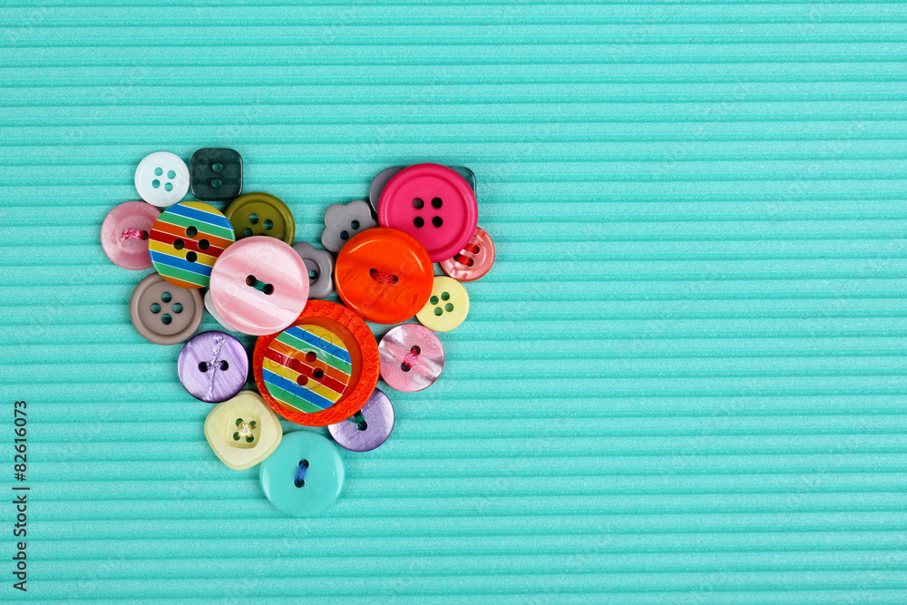Fototapeta premium Sewing buttons heart on cloth background