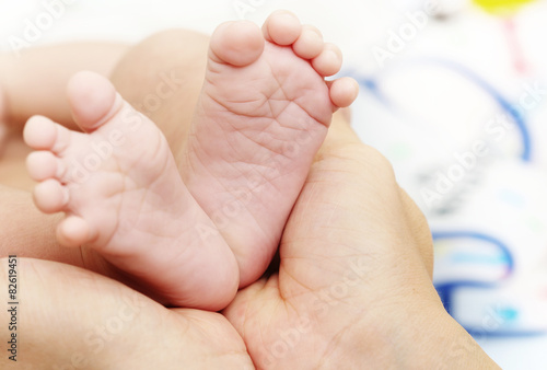 Baby Feet in Mother Hands. New Born Kid Foot © settaphan