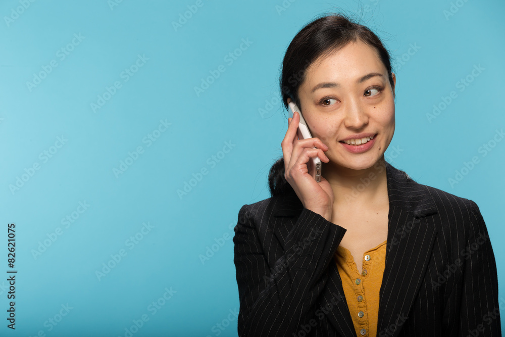 Young Asian woman in studio talking on cellphone Young Asian woman in studio talking on cellphone