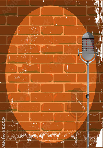 A microphone ready on stage against a brick wall with grunge