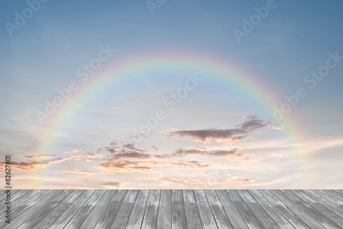 old wooden texture and rainbow in blue sky background