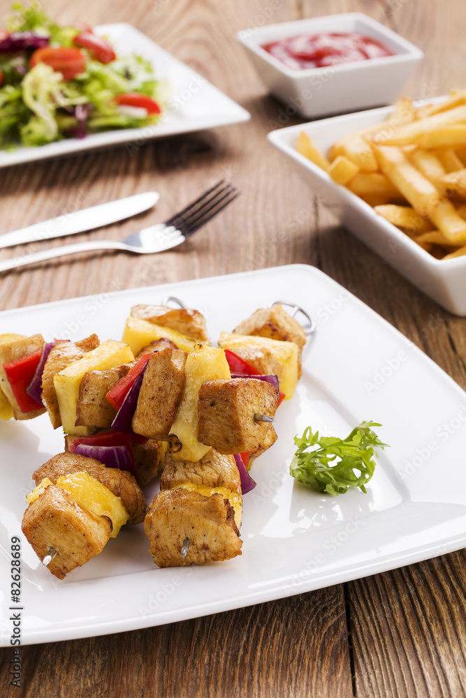 Grilled chicken skewers with pineapple, peppers and onions serve
