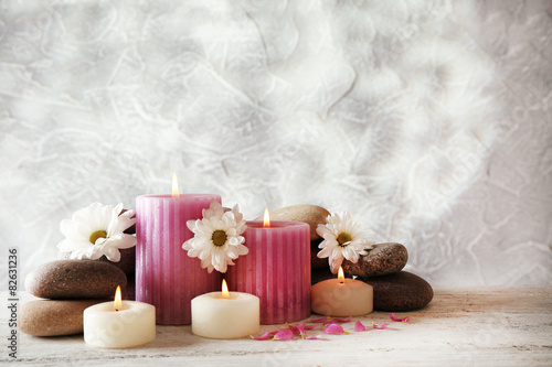 Still life with spa candles on light wallpaper background