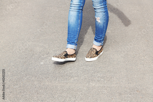 Female feet over gray asphalt background