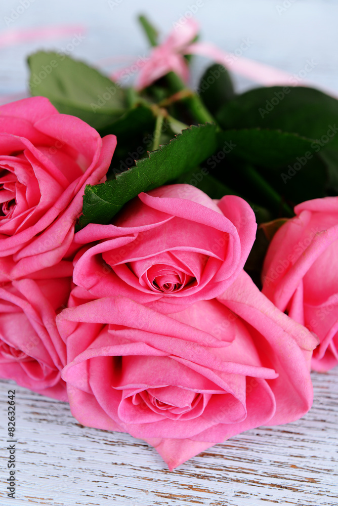 Beautiful pink roses on wooden table, closeup