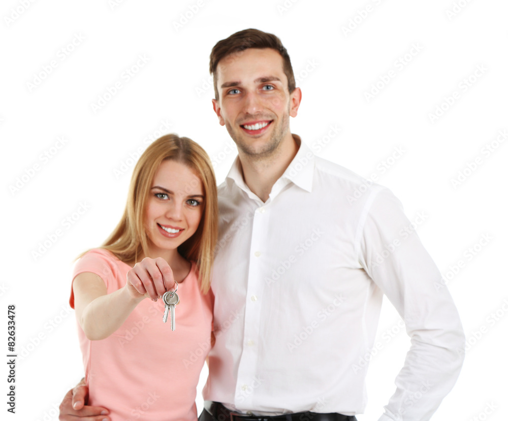 Attractive young couple showing new house key, isolated on white Attractive young couple showing new house key, isolated on white