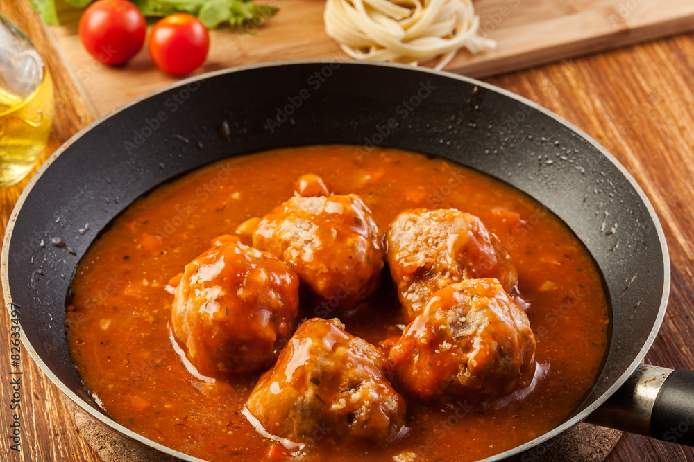 Meatballs with tomato sauce on black pan Meatballs with tomato sauce on black pan