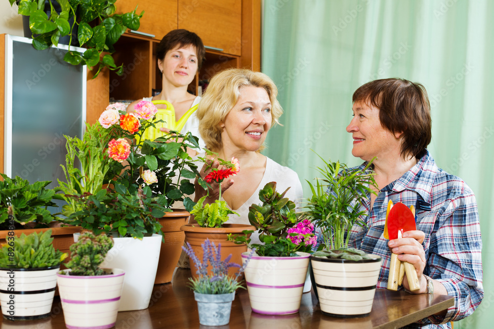 Two mature women and girl taking care of  plants