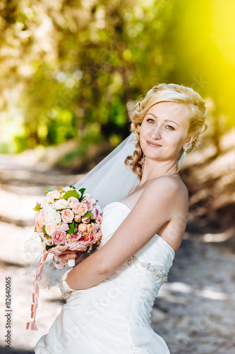 Beautiful bride outdoors. Bride holding wedding bouquet outside