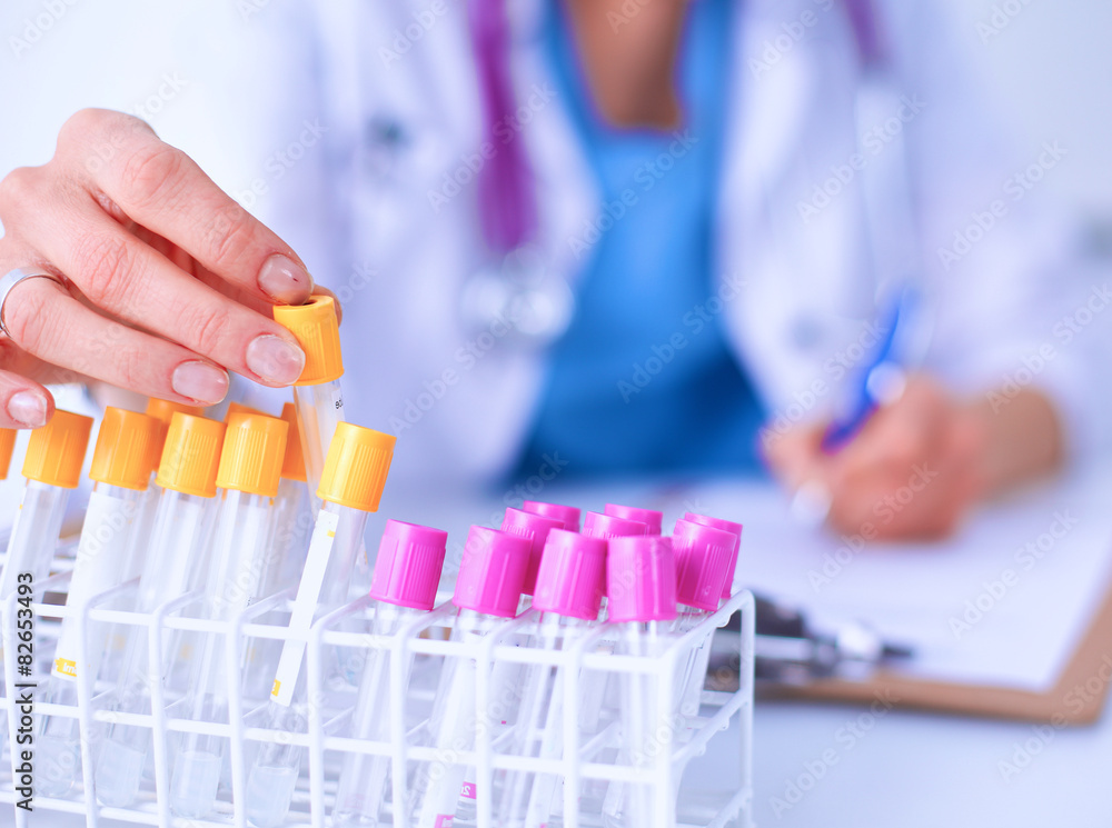 Woman researcher is surrounded by medical vials and flasks Woman researcher is surrounded by medical vials and flasks