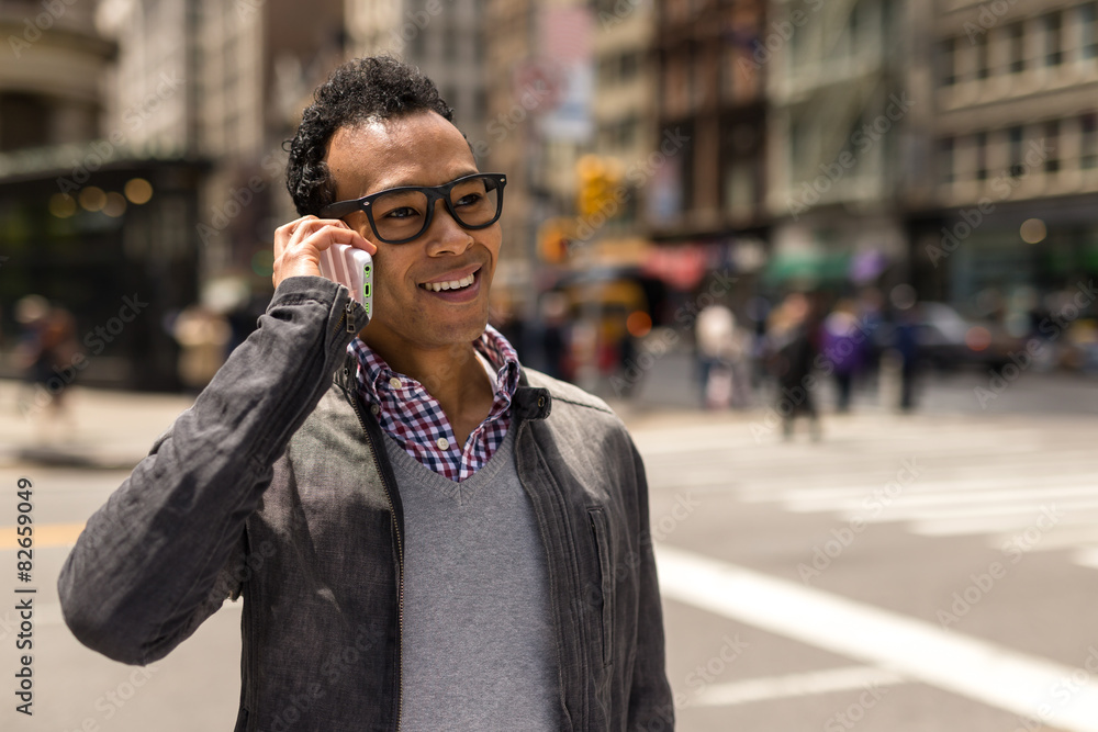 Young African Asian man in New York City talking on cell phone