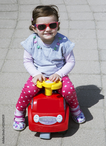 Bimba con occhiali da sole e brum brum photo