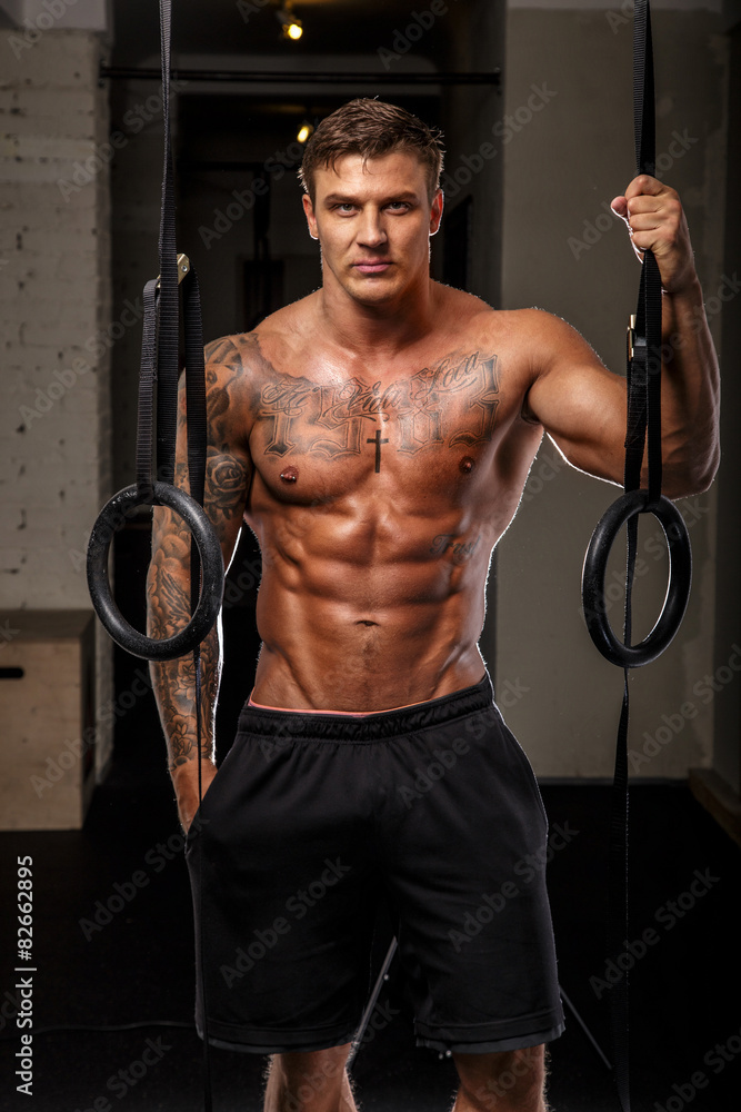 Muscular man with tattooes in a gym Muscular man with tattooes in a gym