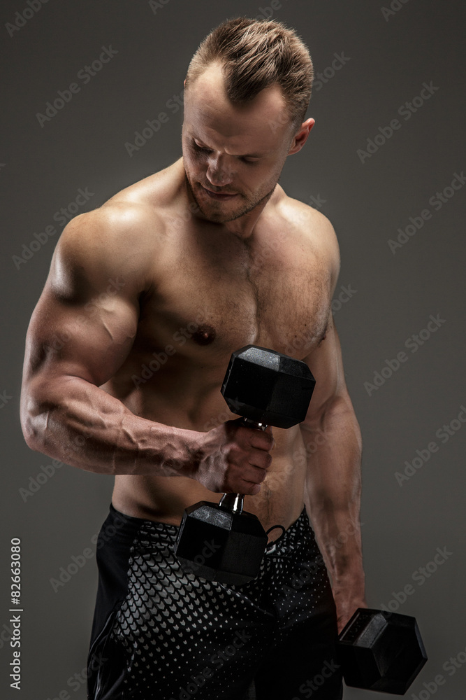 Naklejka premium Awesome muscular guy with dumbell
