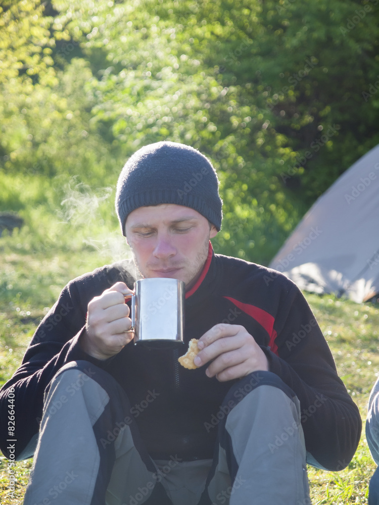 A man drinking from a Cup and eating cookies. A man drinking from a Cup and eating cookies.