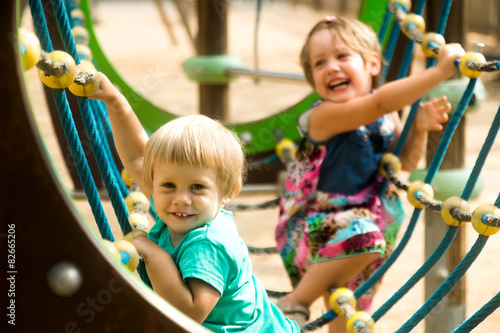 Obraz na plátně Little sisters at playground in park