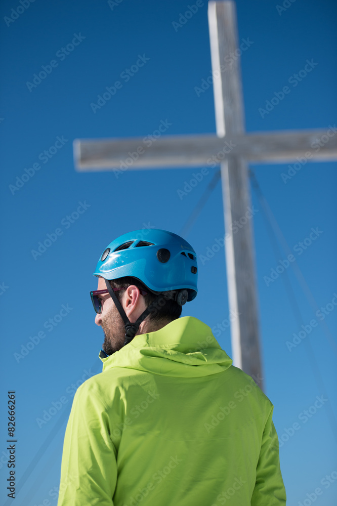 Junger Mann am Berg vor Gipfelkreuz Junger Mann am Berg vor Gipfelkreuz