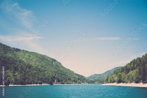 Türkiser See und grüner Wald unter blauem Himmel © Arthur Braunstein