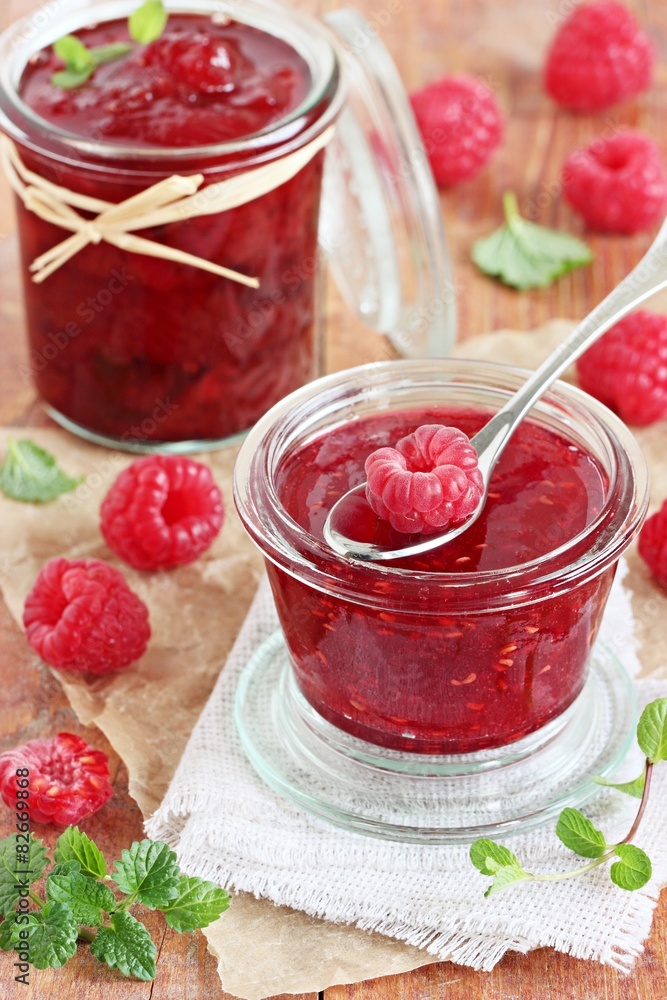 Homemade delicious raspberry jam on a rustic wooden table Homemade delicious raspberry jam on a rustic wooden table