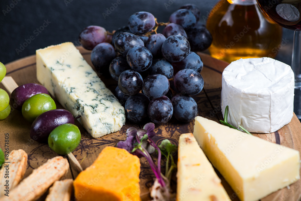 Cheese board with fresh grapes,herbs and olives